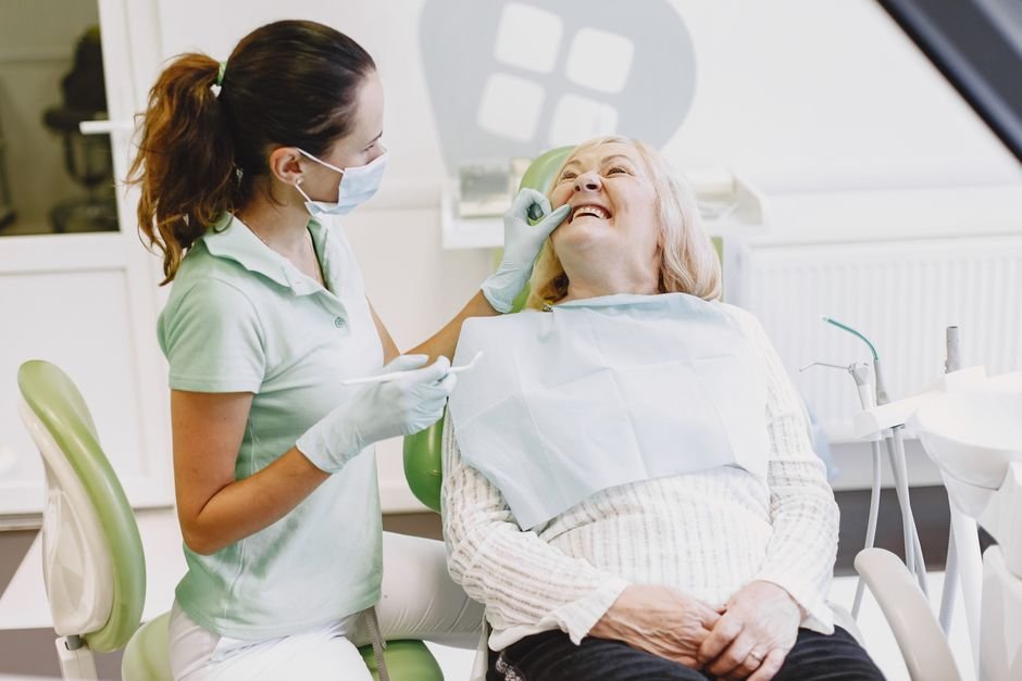 Dentist holding a denture model while explaining whether dental insurance covers dentures