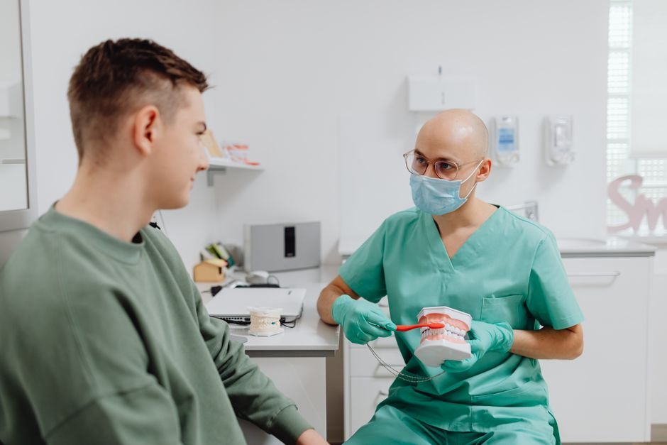 Young college student at a dental checkup discussing dental insurance options